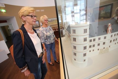 Frau schaut sich Modell der Wewelsburg in einer Vitrine an